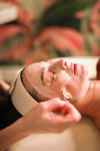 Relaxing facial treatment with a rejuvenating mask applied by a professional therapist at Scents of Serenity Day Spa.
